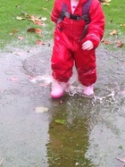 toddler splashing in a puddle